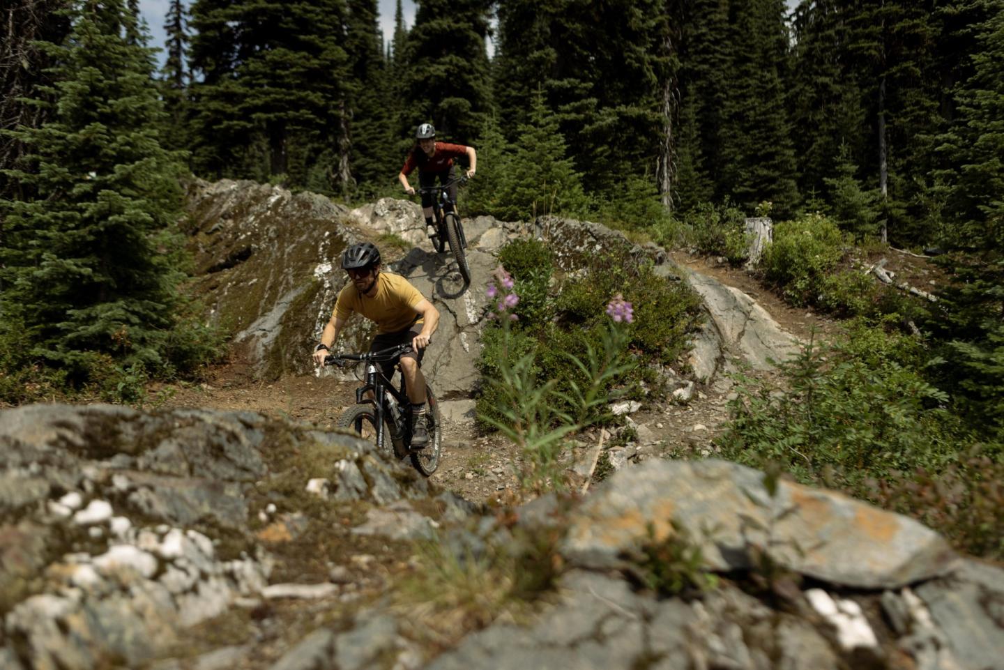 two mountain bikers riding down rocky terrain