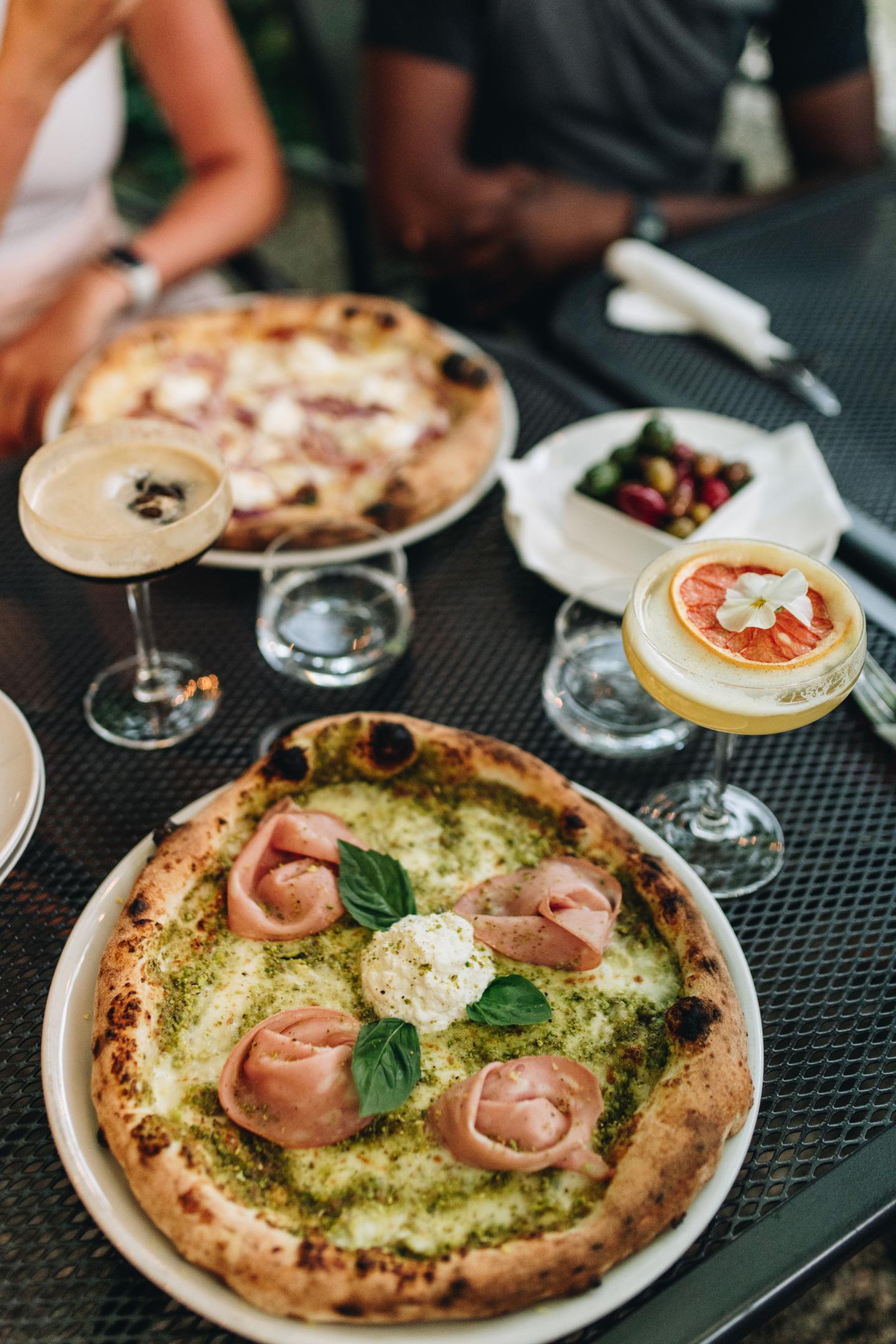 A close up of pizza and cocktails