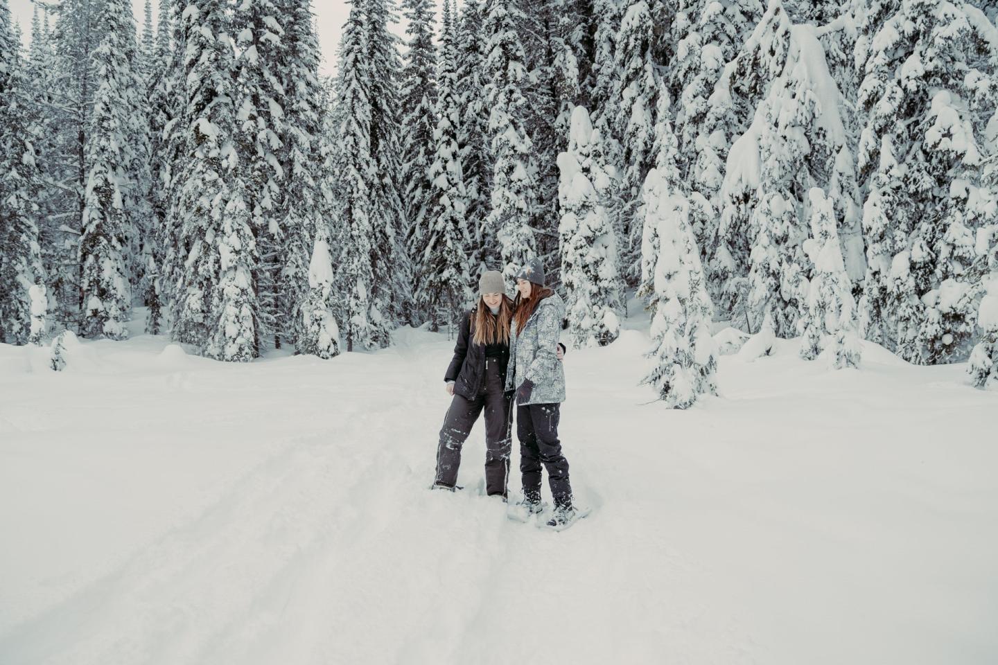 two girls smiling together while snowshoeing