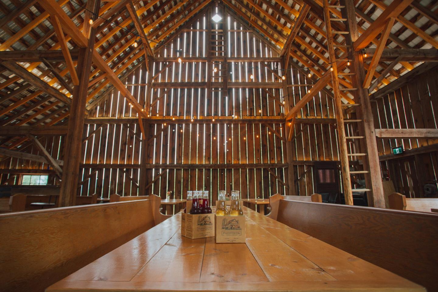 6 packs of cider sitting on a table in a barn