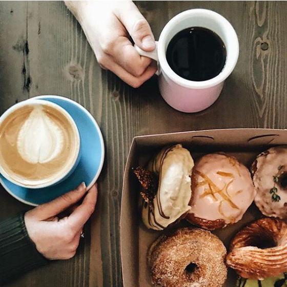 Two people enjoying coffee and doughnuts