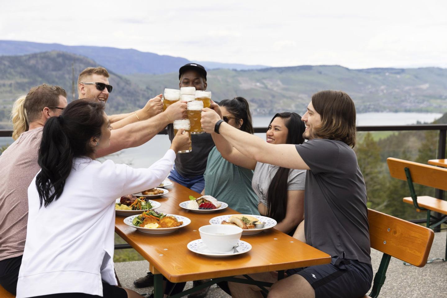 Group of men and women enjoying a pint of beer and food on the patio at Gerni's Farmhouse