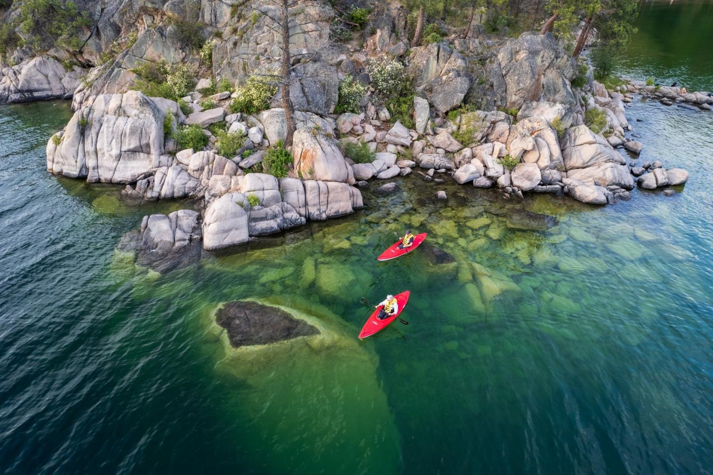 two kayakers along the pristine shoreline of Okanagan Lake