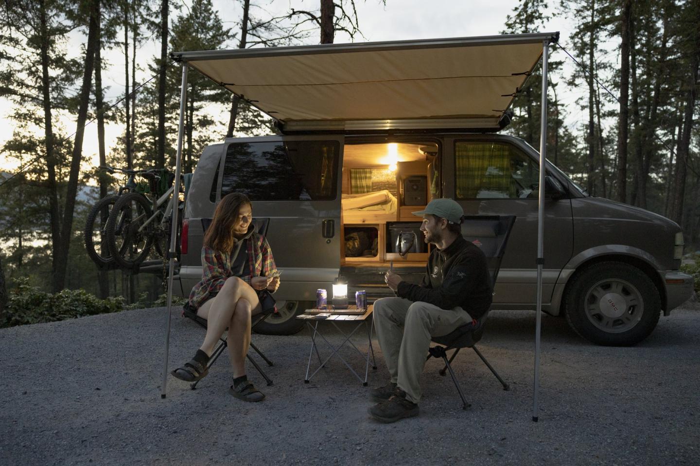 couple camping next to vehicle at campground
